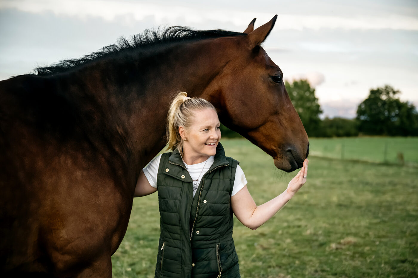 Horse and lady standing in field