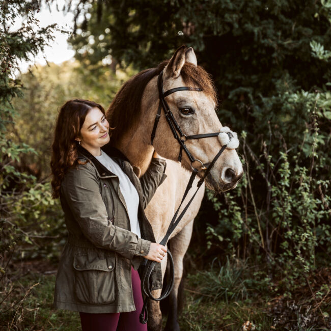 Female standing next to a horse
